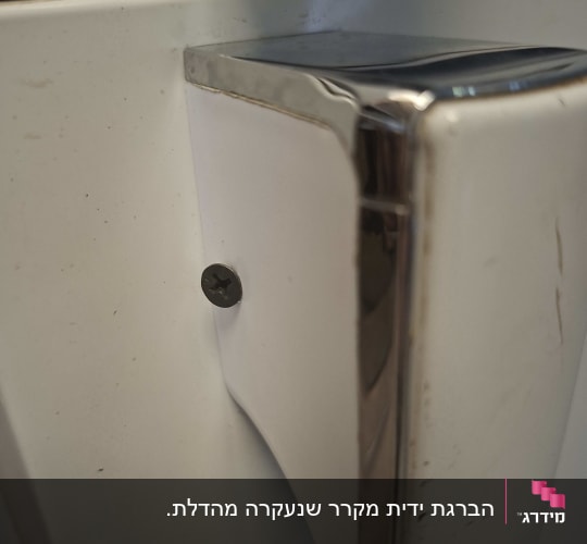 תקריב של חיבור ידית מקרר ביתי באמצעות בורג